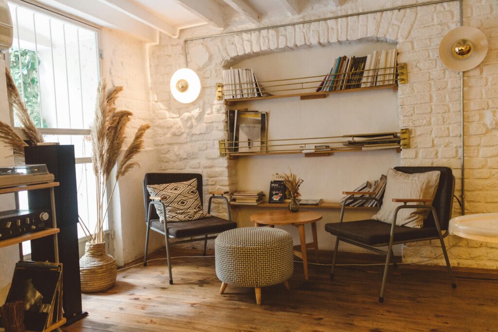 Inviting modern rustic living room featuring armchairs, an ottoman, and a stylish bookshelf.